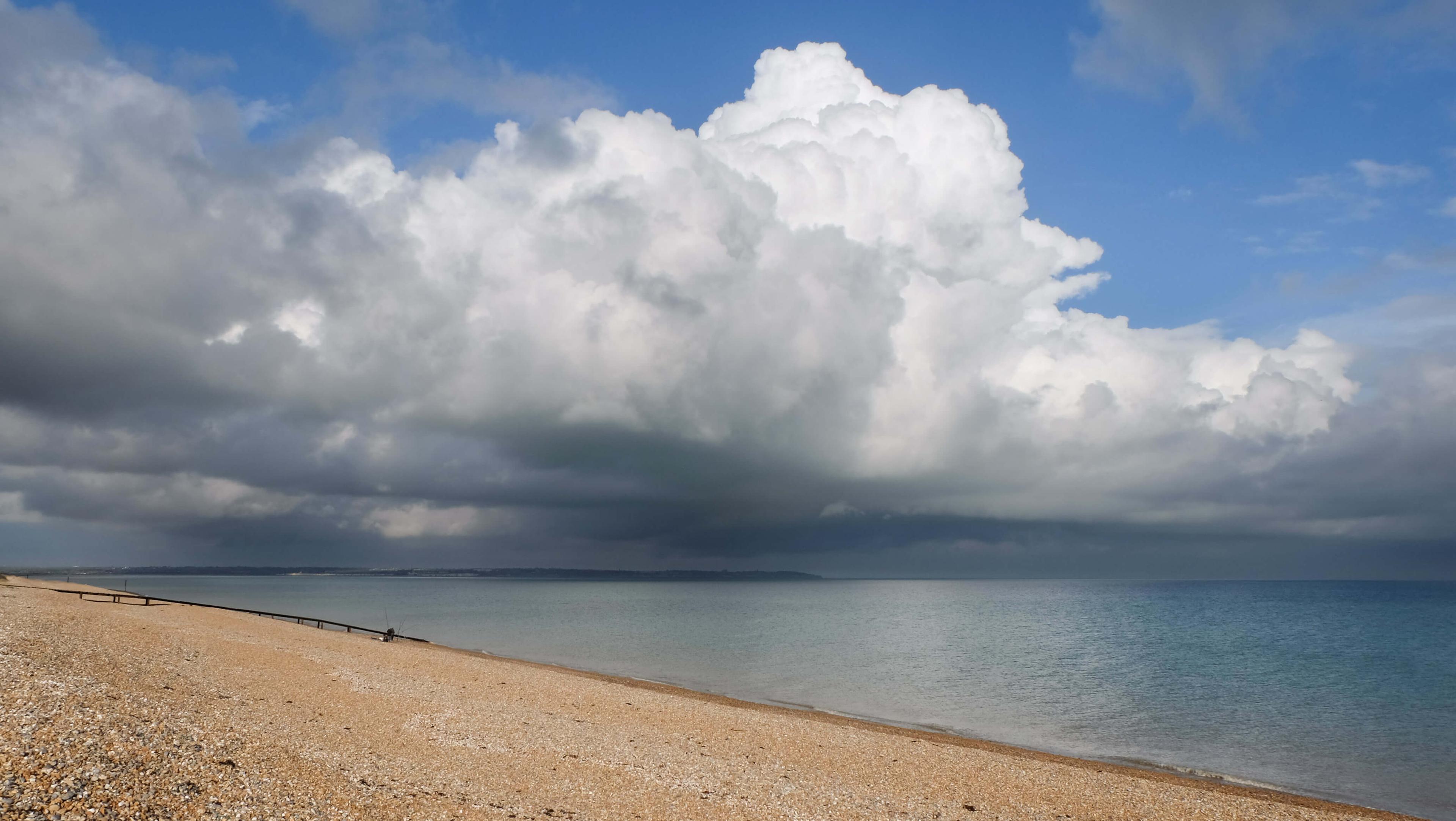 Storm clouds building over a Sandy bay. 