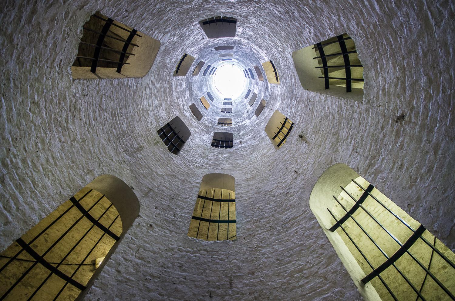 A triple, spiral stairway, looking up through the main shaft towards the sky. Their are windows all the way to the top.